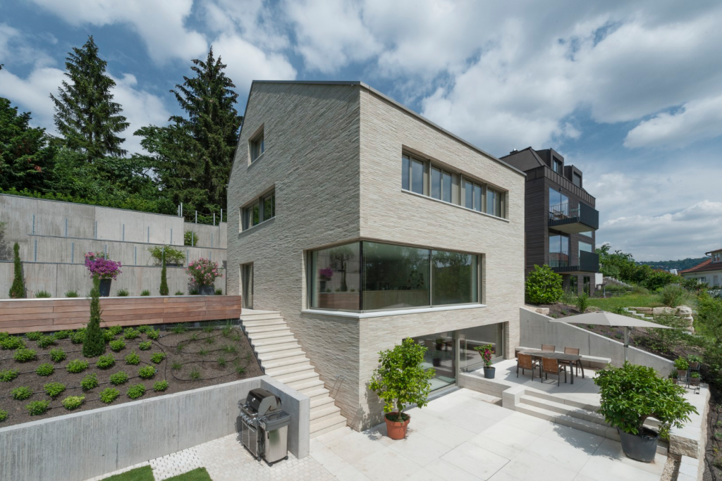 Haus mit Treppe, weitläufigem Garten und Terrasse.
