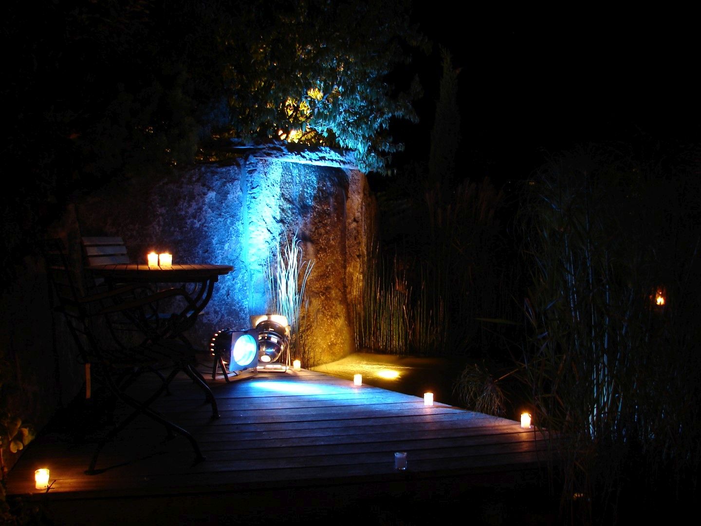 Stimmungsvoll beleuchteter Wasserfall und Teich bei Nacht.