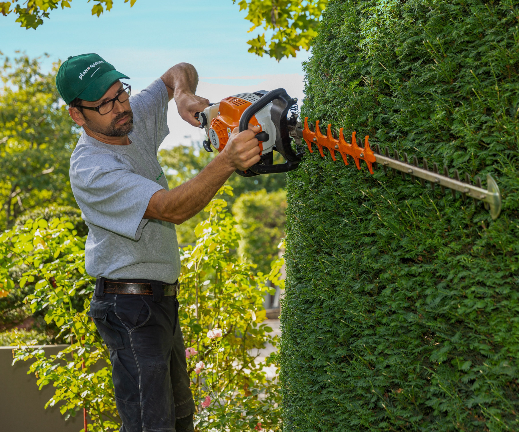 Mitarbeiter mit einer Heckenschere.