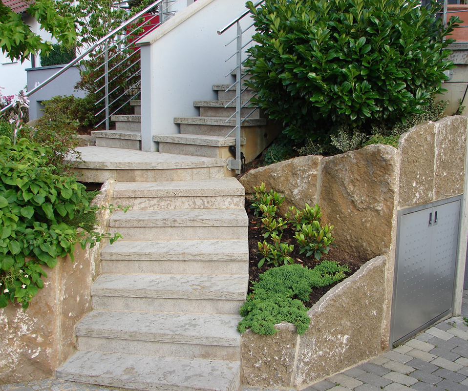 Kurze, steinerne Treppe, die zur einer Haustür führt.