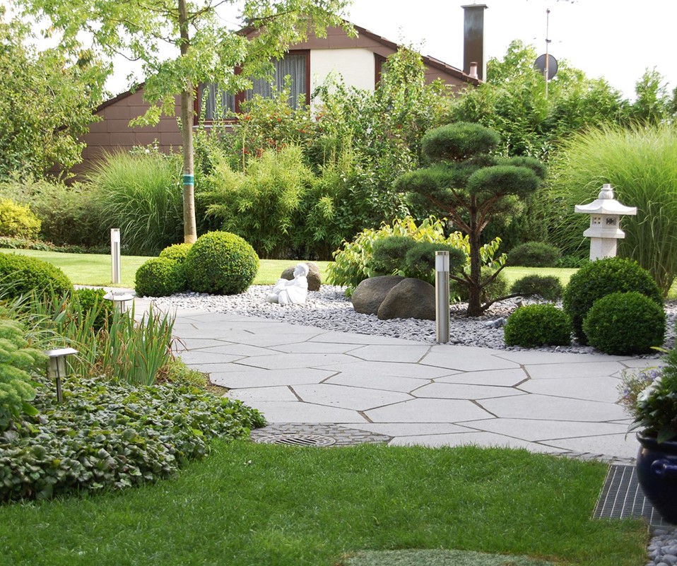 Steinerner Weg durch einen Garten.
