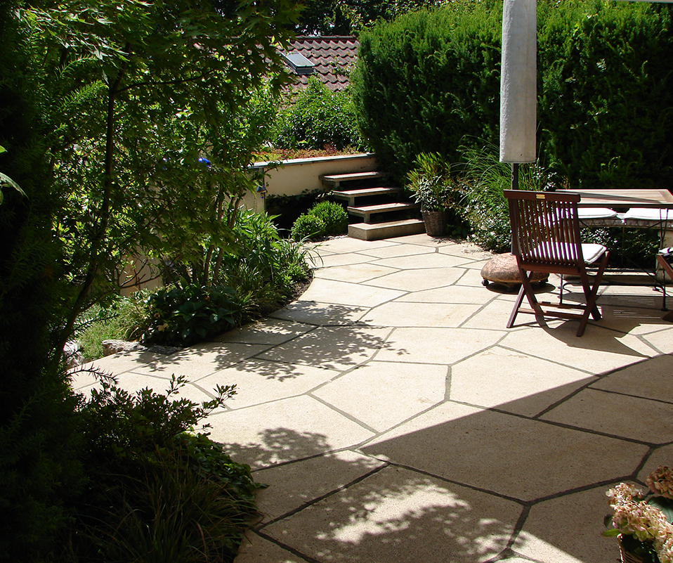 Sonnige Terrasse, umgeben von viel Grün.